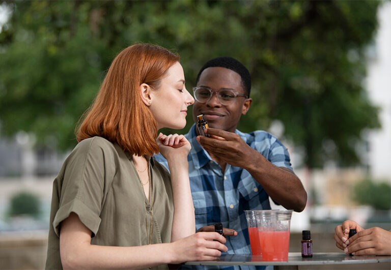 juodaodis vyras ir moteris mėgaujasi doTERRA eteriniais aliejais lauke